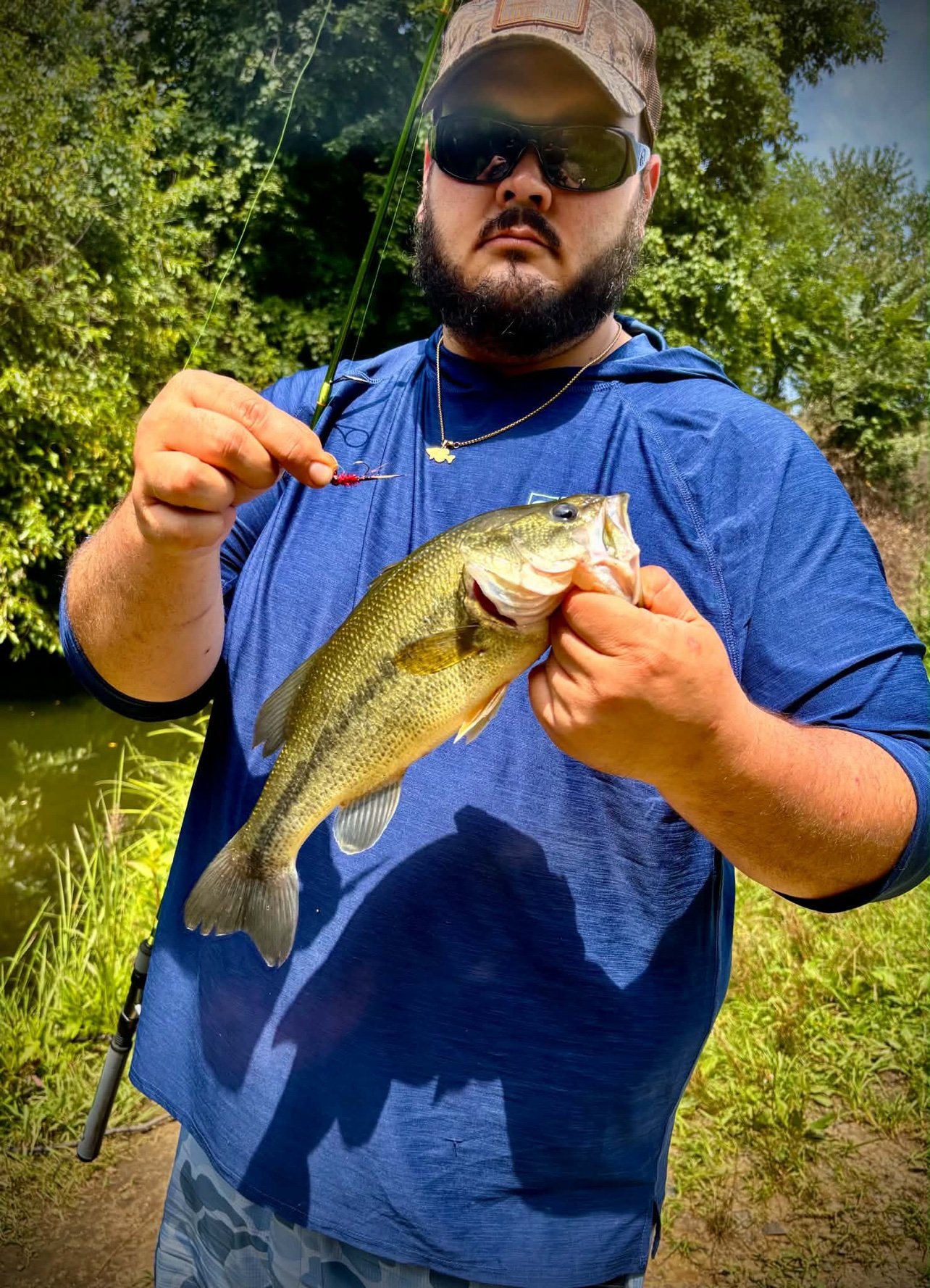 Austin Fairchild holding a bass and a small red jig